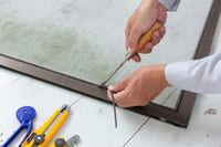 A handyman fixing a window